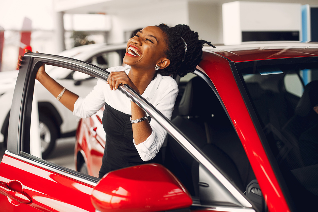 Happy woman with a red car
