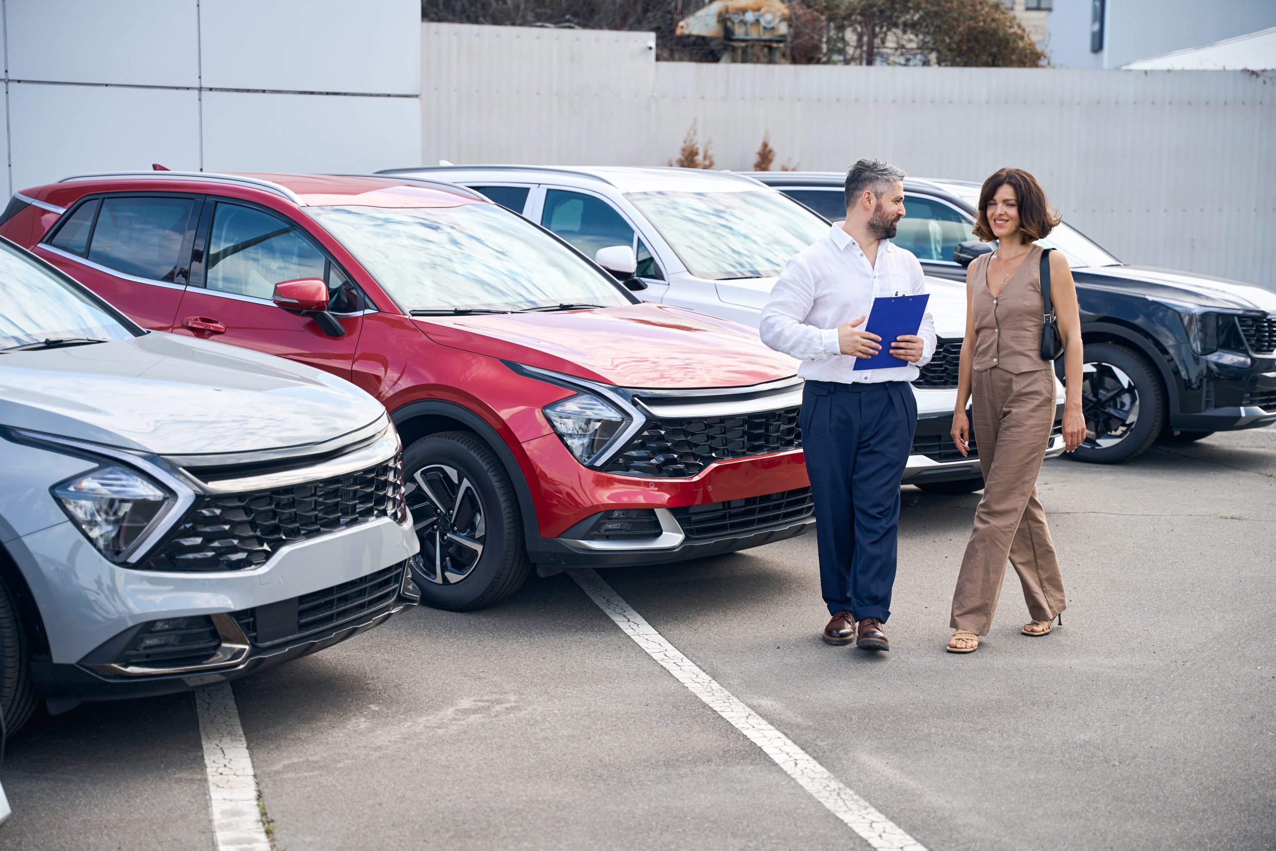 Customer and sales rep talking near used cars