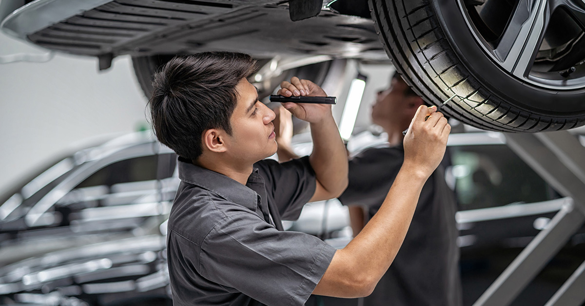 Service technician inspecting for even tire wear