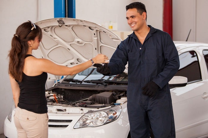 Woman handing her keys to a service tech